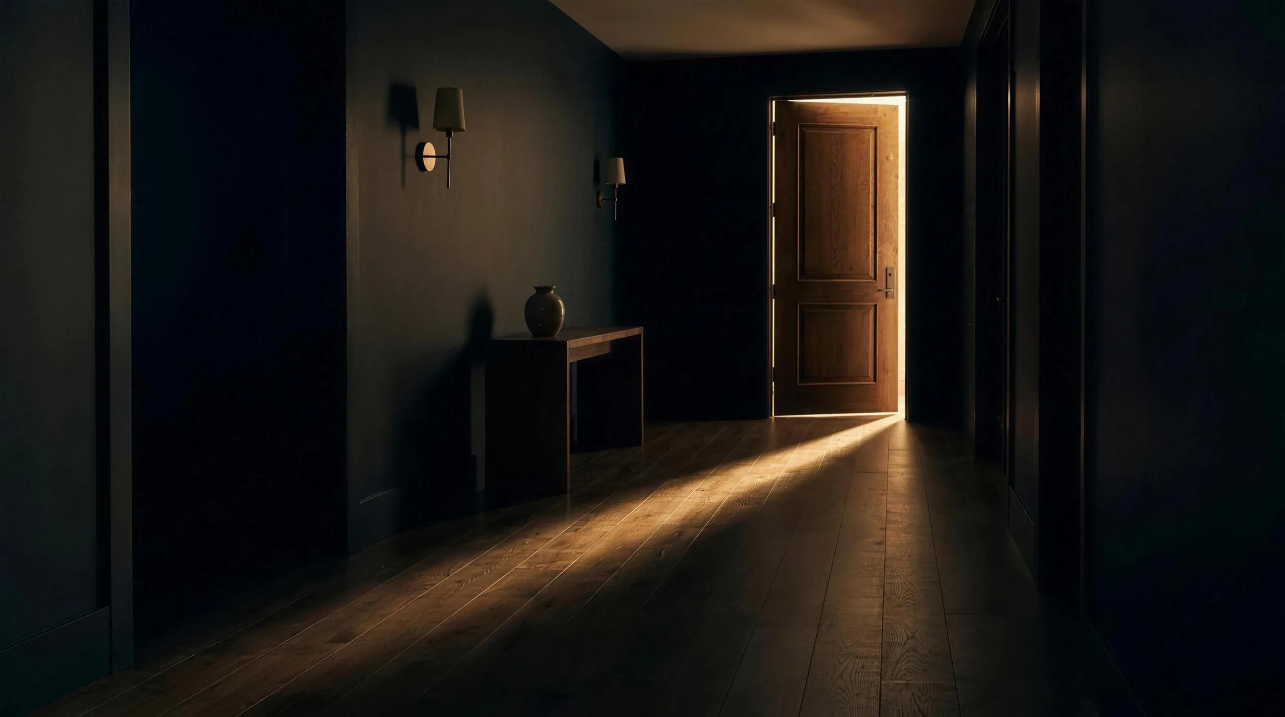 Evening light spilling from a doorway across dark wood floors